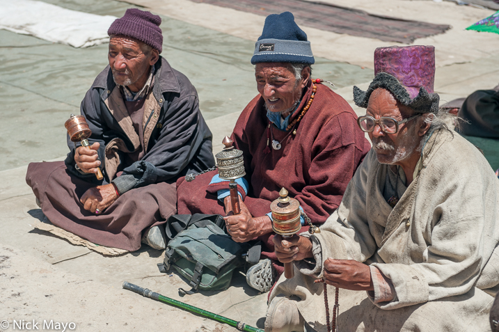 Ladakhi men holding prayer wheels at a religious assembly in Lamayuru.