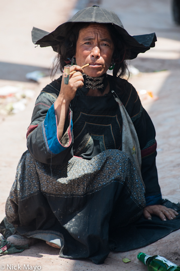 A Suo Di Yi woman smoking a pipe in Niuniuba market.