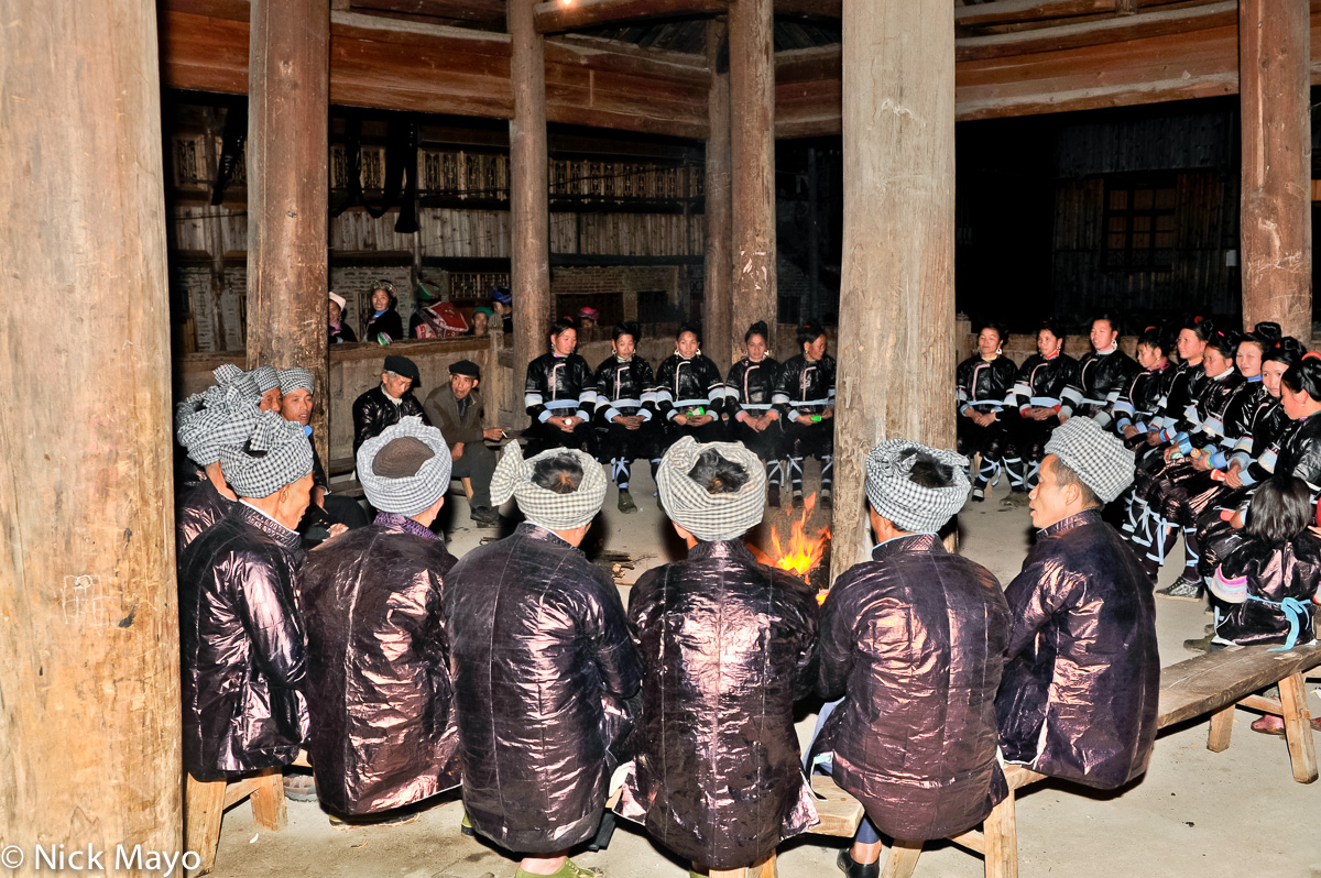 Traditionally dressed Da Ge groups singing antiphonally while seated in a drum tower at a Dong festival in Xioahuang.