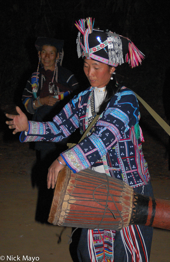 A Pin Toh Aini (Hani) woman hand drumming on a frame drum at a New Year festival in Chung Tsai.