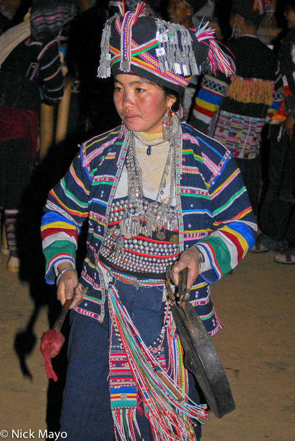 A Pin Toh Aini (Hani) woman beating a gong at a New Year festival in Chung Tsai.