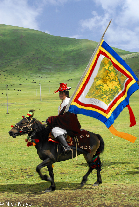 A Tibetan horsemen carrying a standard at the opening day of a Sershul horse festival.