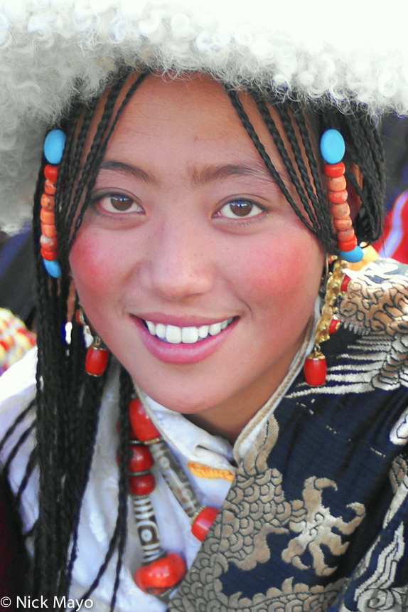 A Tibetan girl with beaded hair pieces at a Sersul horse festival.