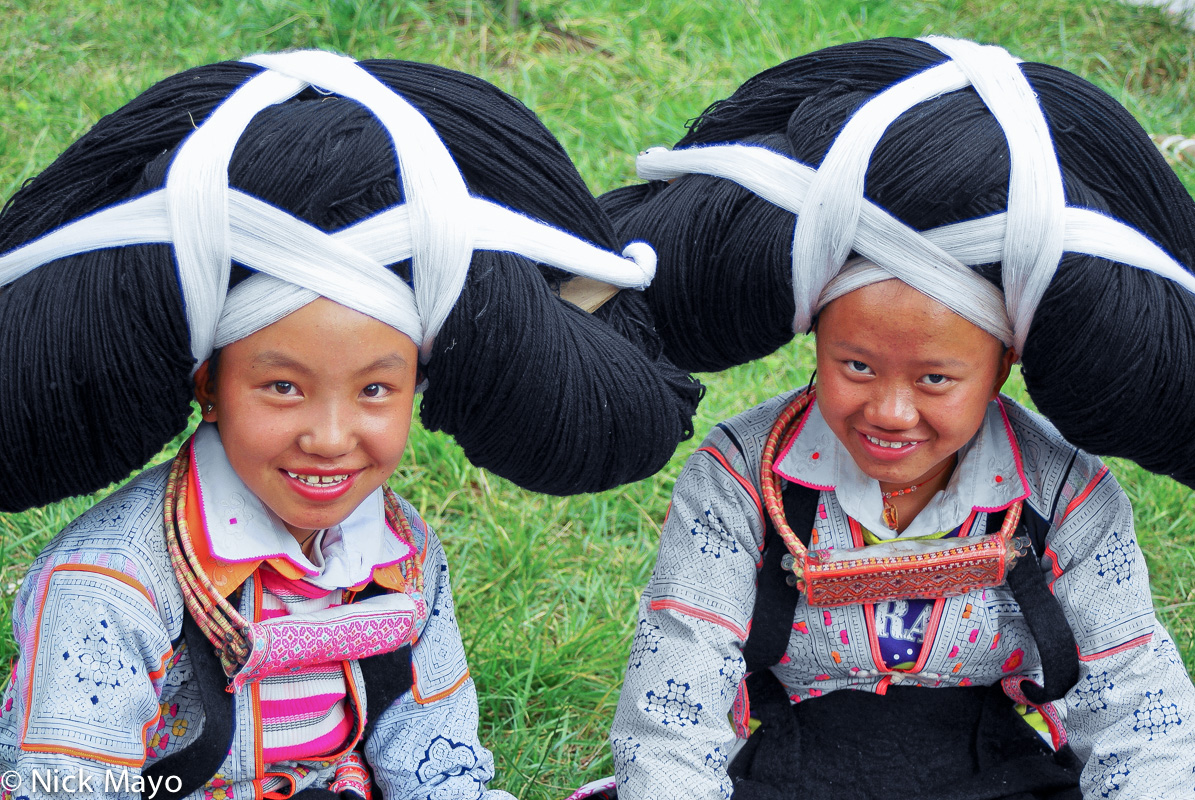 Two Qing Miao girls from Longee wearing the traditional hair piece.