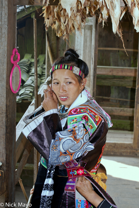 A woman from Pai Shiao village dressing up in traditional festival clothes and sporting an embroidered hair band.