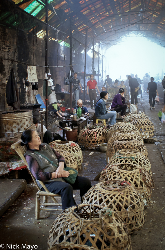 Vendors selling live poultry held in baskets at Rongjiang market.