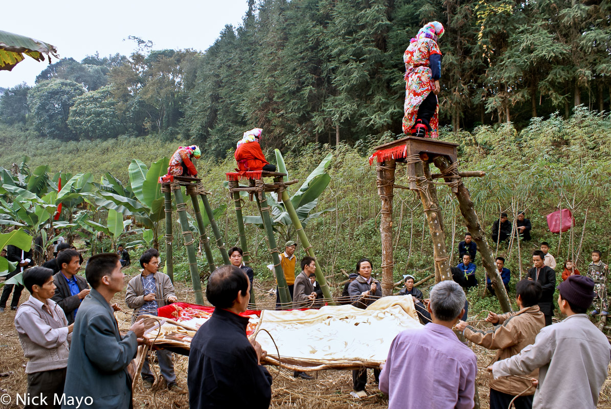 A dujie initiate awaiting the instruction to fall backwards from the platform onto the blanket covered vine net at the Yao village...