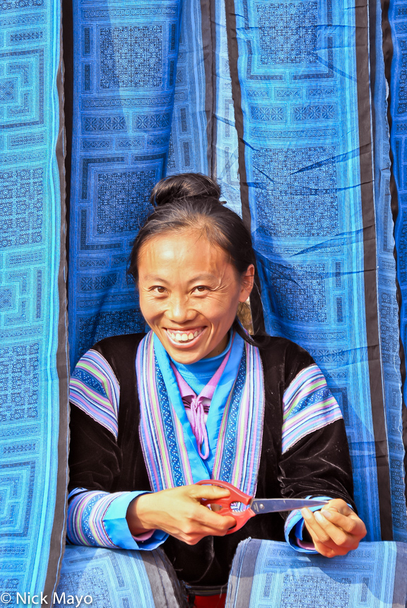 A Miao vendor at San Ja market selling blue batik style cloth.