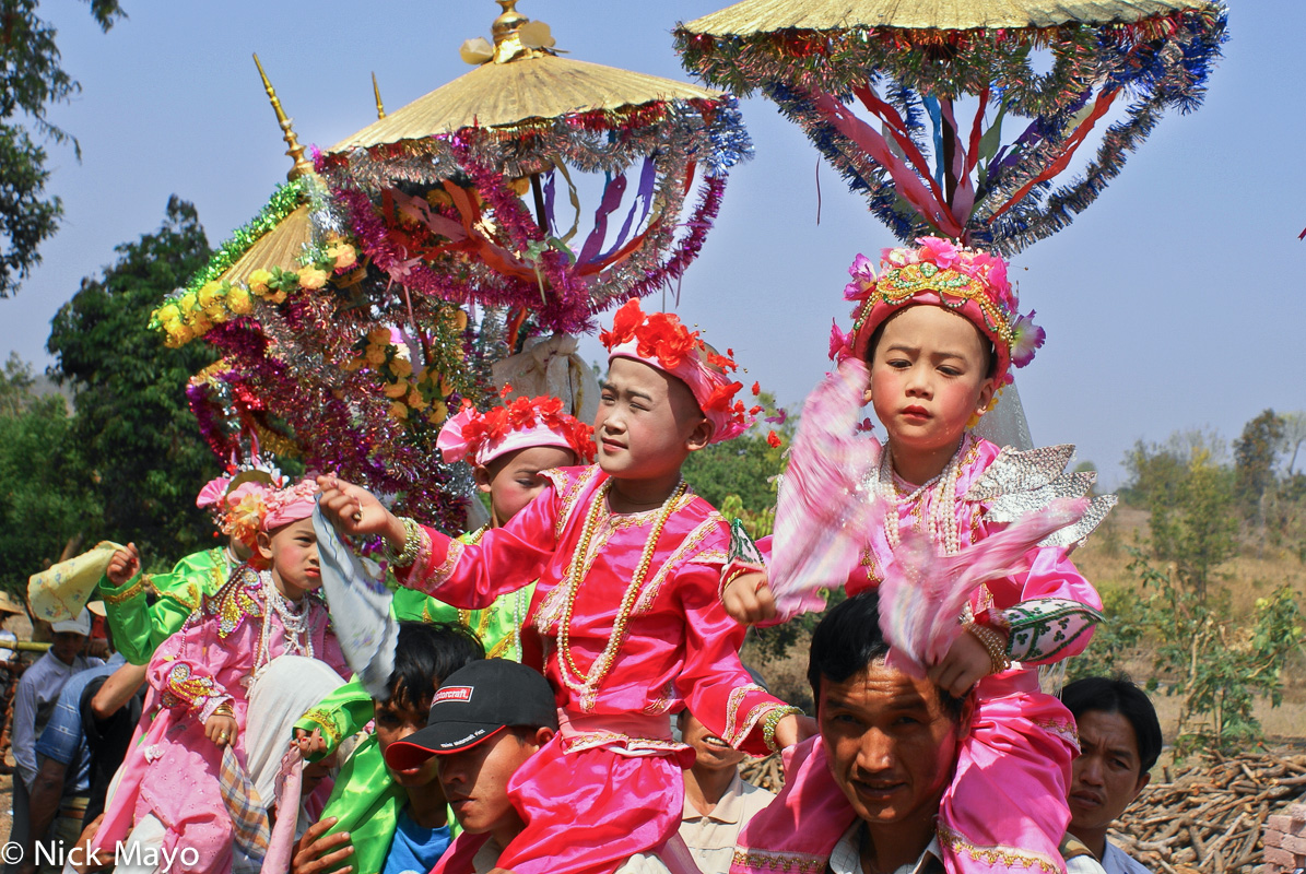 Young boys being carried under golden parssols in a procession at a shinbyu (novitiation ceremony) at a Shan monastery in Kyaukme...