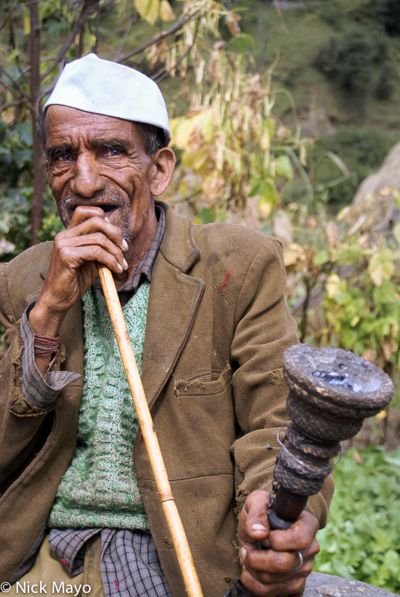 A man smoking his long stemmed pipe in Kema village in the Ram Ganga valley.