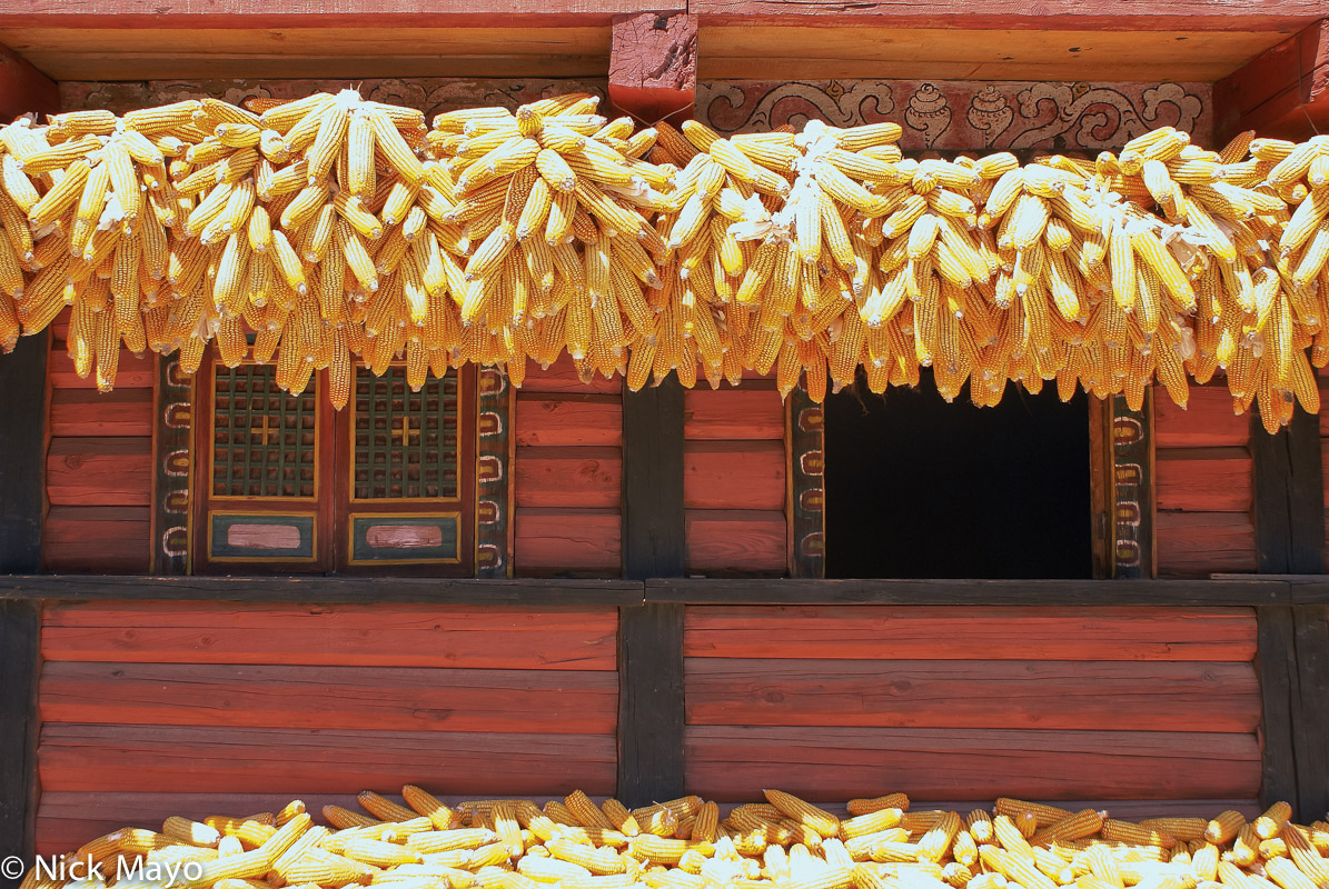 Drying corn hung from the eaves of a wooden Gyarong Tibetan residence at Balang.