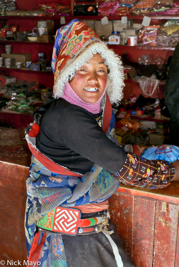 A traditionally dressed Tibetan lady at a store in the village of Arikdza.