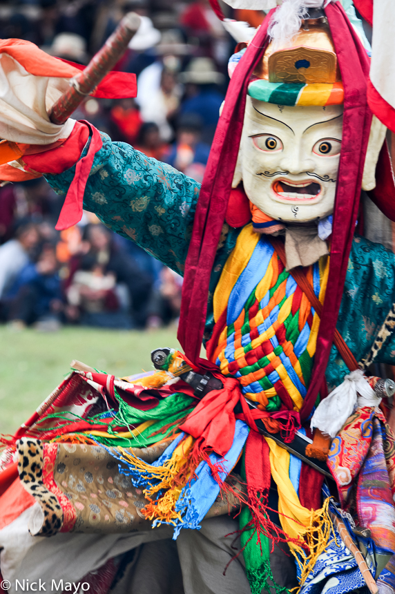 A masked Tibetan monk dancing at a festival at the Yazer Gon monastery in Manigango.