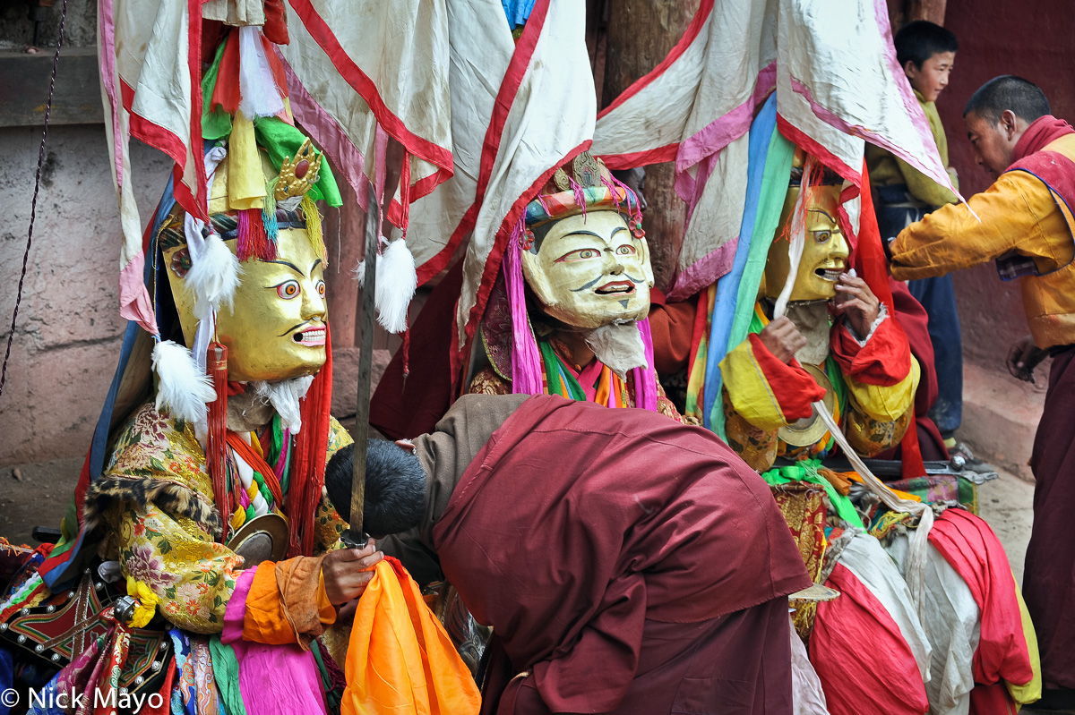 Masked Tibetan monks having their dancing attire checked at a festival at the Yazer Gon monastery in Manigango.