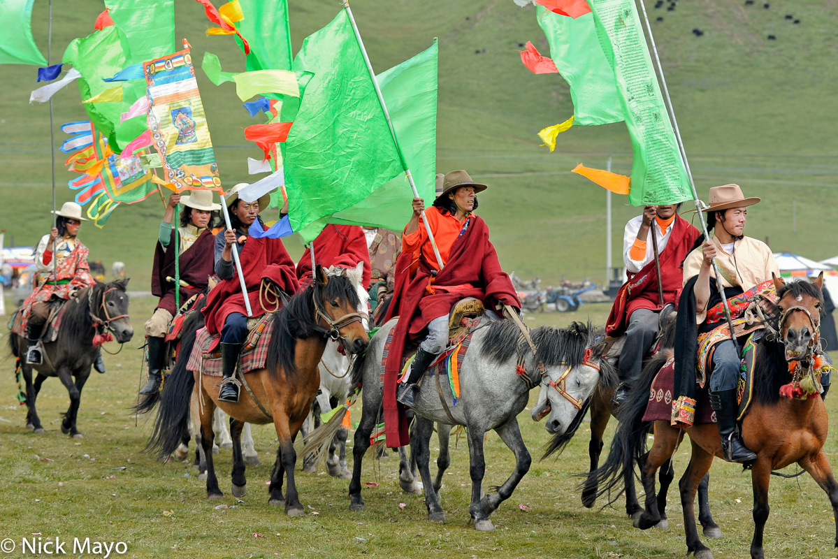 A group of Tibetan horsemen carrying standards at a horse festival in Sershul.