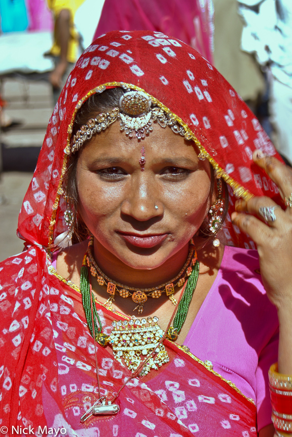 A Jodhpur woman wearing a jewelled head band, head scarf, earrings and bracelets.