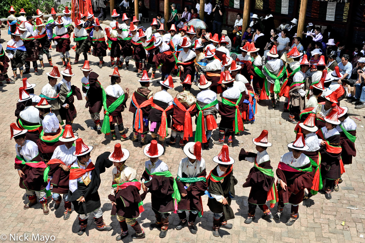 Tibetan men in a winding procession at a monastery festival in Rongpo Gyakhar.