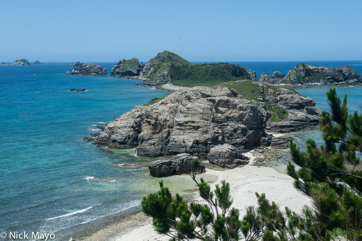 A promontory connected by a sandy beach to the island of Aka.