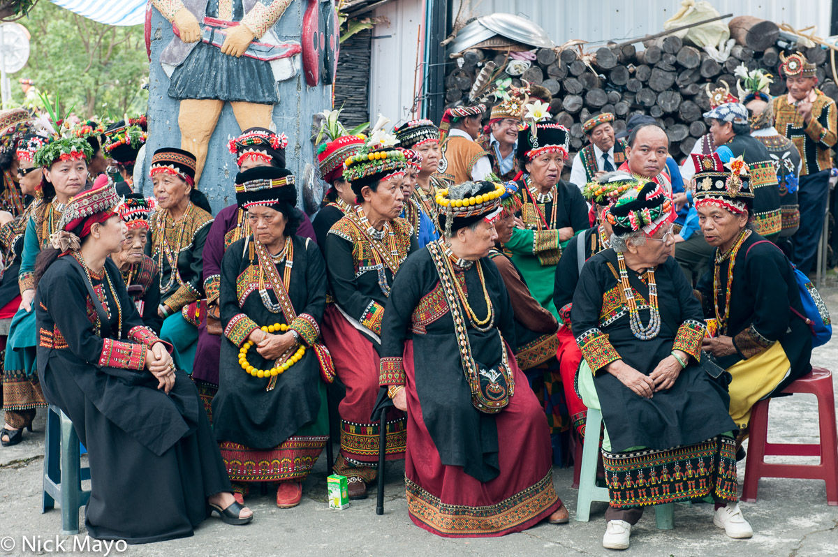 Rukai women, wearing traditional hats and necklaces and carrying hand stitched bags, at a wedding in Wutai.