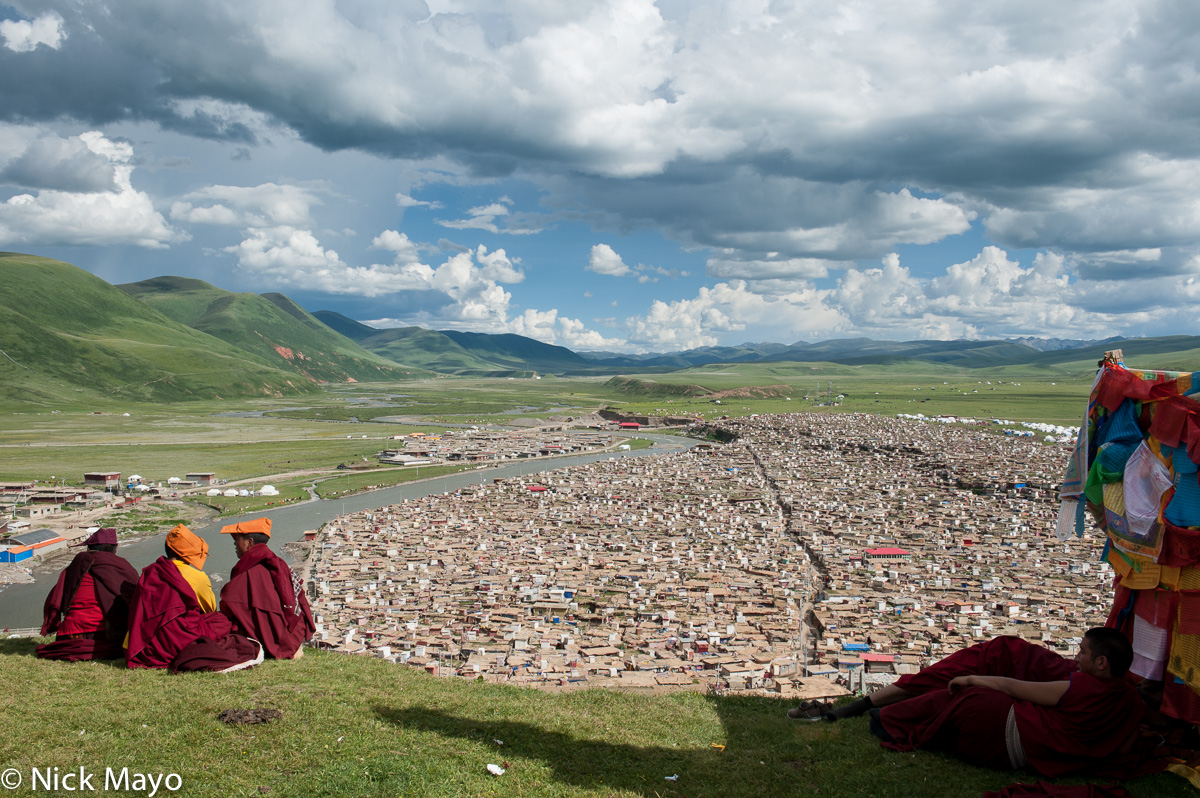 Tibetan monks and nuns resting on the hill above the juemu village at Yaqing.