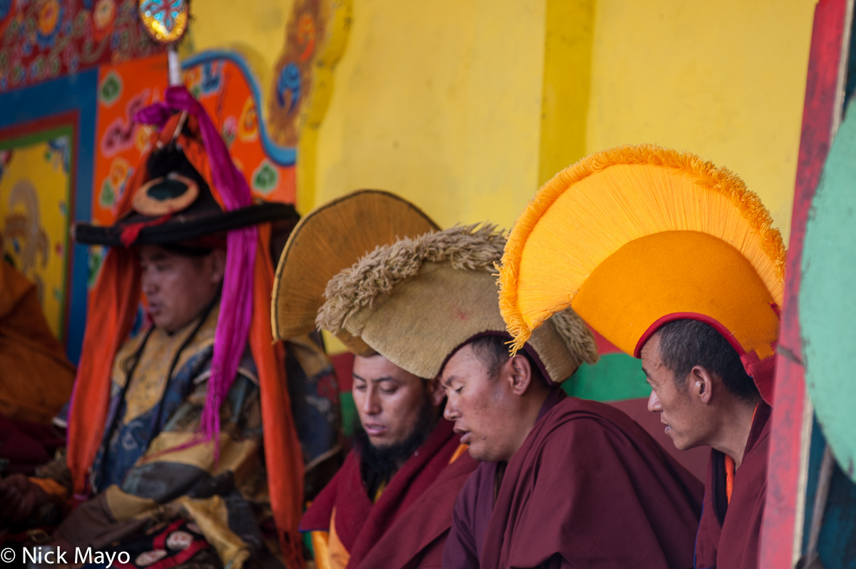 A monk in a traditional yellow hat at a Tibetan festival in Manigango.