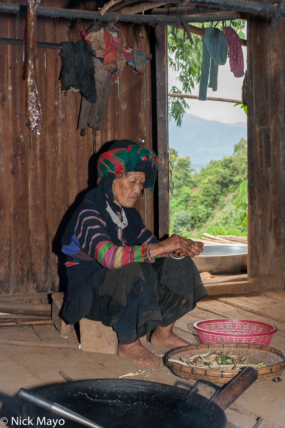 A Red Yi woman preparing vegetables in the village of Powu.