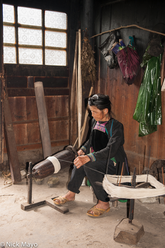 A Dong woman spinning yarn on a hand powered spindle in the village of Gaochien.