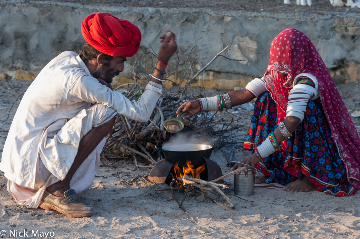 A Rabari shepherd and his wife cooking dinner at their campsite on the annual migration route near Ambaji.