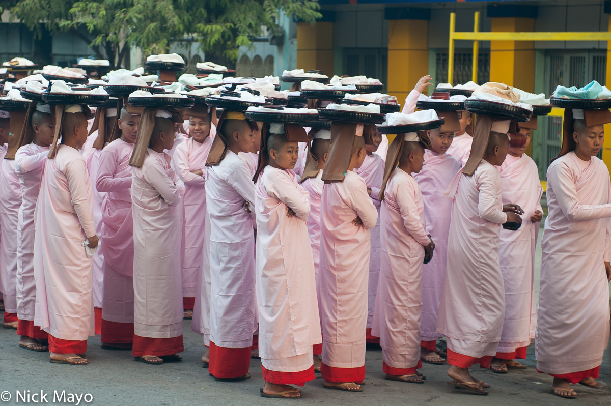 Nuns waiting to commence their daily pindacara (alms collecting) in the Mahamuni temple area of Mandalay.
