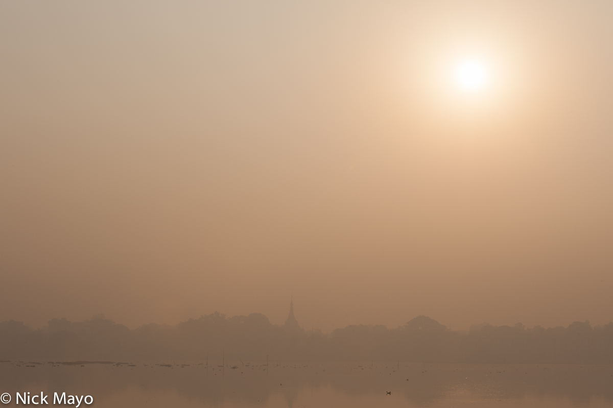 Looking across Mandalay Kantawgyi lake to a pagoda at sunrise.