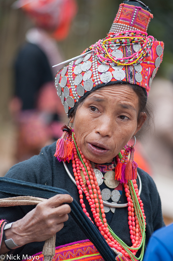 A Loma woman wearing a traditional turban, earrings and necklace at Paknamnoy market.