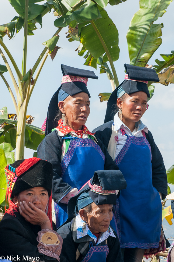 Women wearing traditional clothes, hats and earrings at a wedding in the Hani village of Huatien.
