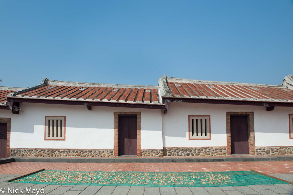 The side wing of a courtyard farmhouse near Xinpu with traditional windows.