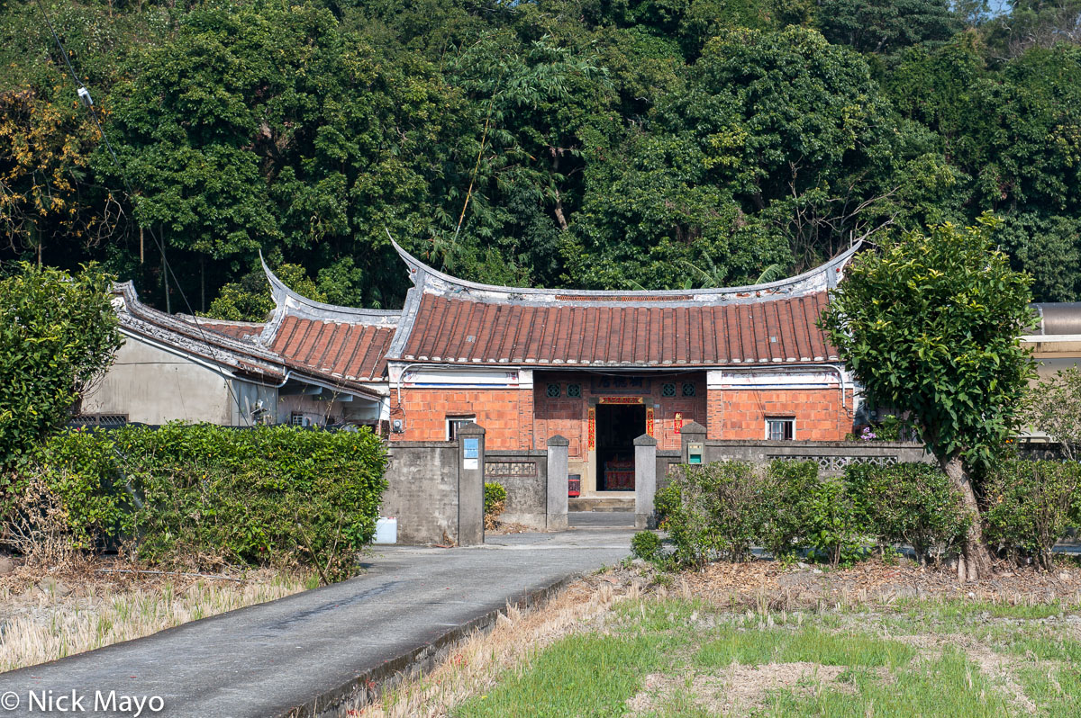 A traditional farmhouse with a swallow tail roof near Xinpu.