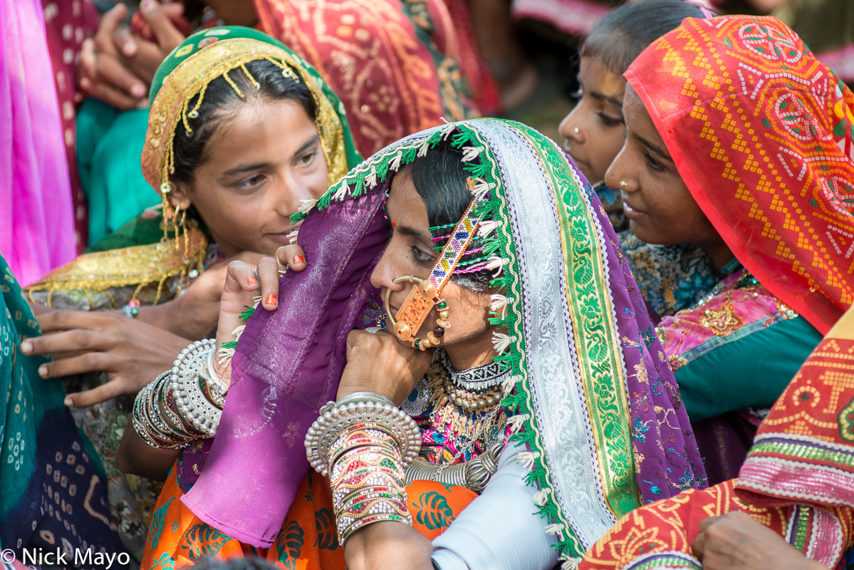 A Meghwal woman, wearing a head scarf, nose ring, white arm bangles and bracelets, at the Saang Wari fair in Ratanpar, Kutch.