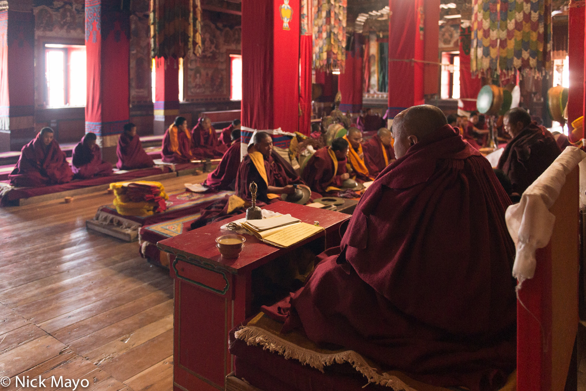 Monpa monks, one with a hand bell, chanting at the Torgya festival in the Tawang monastery.