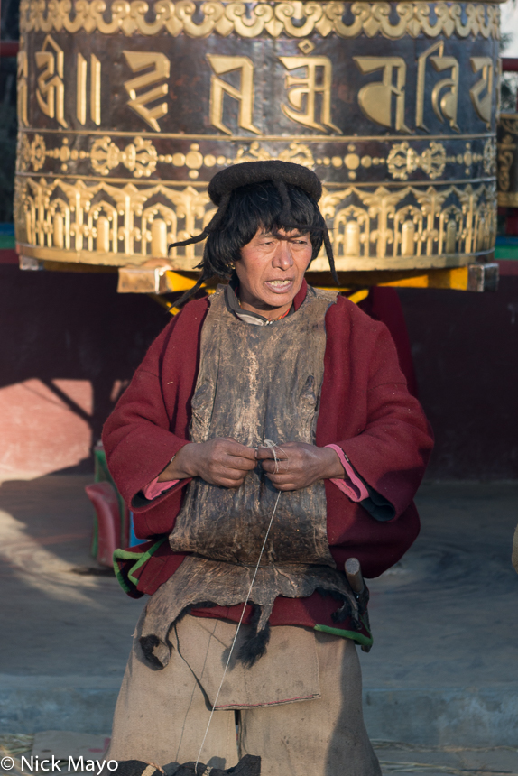 A visiting Dakpa trader, wearing a traditional hat and a skin apron, at the Torgya festival in the Tawang monastery.