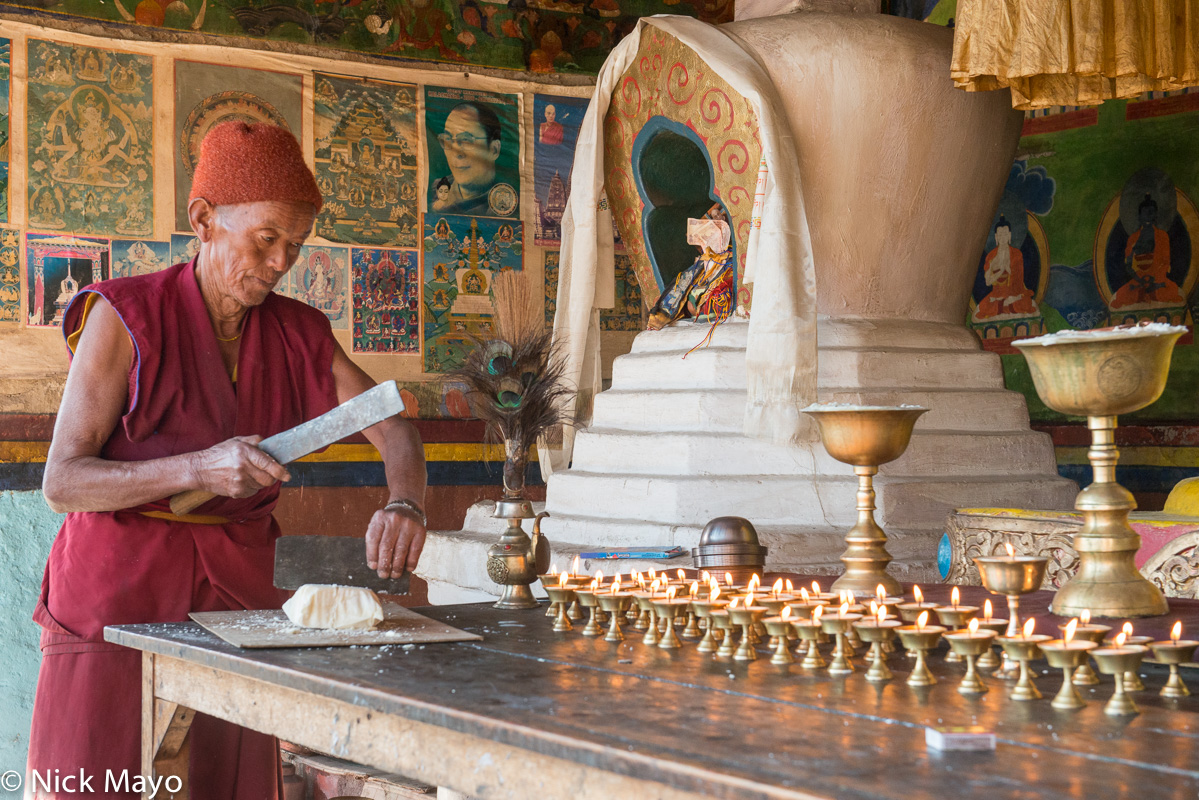 A Monpa monk slicing yak butter to be burnt in votive lamps at the Torgya festival in Tawang.