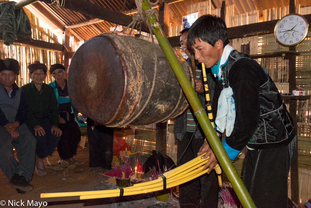 A piper and drummer playing ritual music to appease the spirits at a festival in the White Hmong village of Ban Hong.