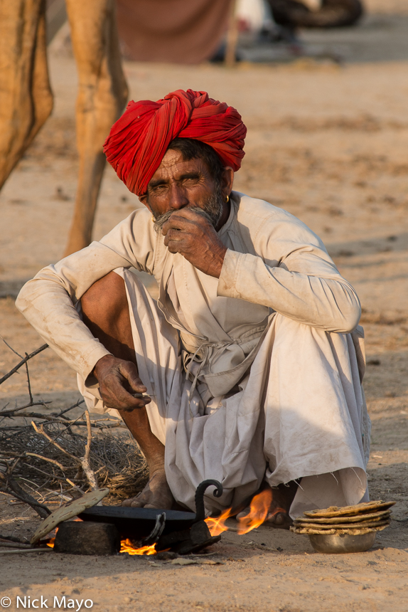 A Rabari man cooking chapatis during the Mallinath fair at Tilwara.