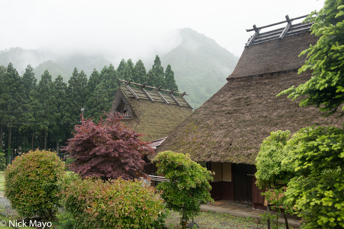 A farmhouse and barn, both with thatched roofs, near Miyama.