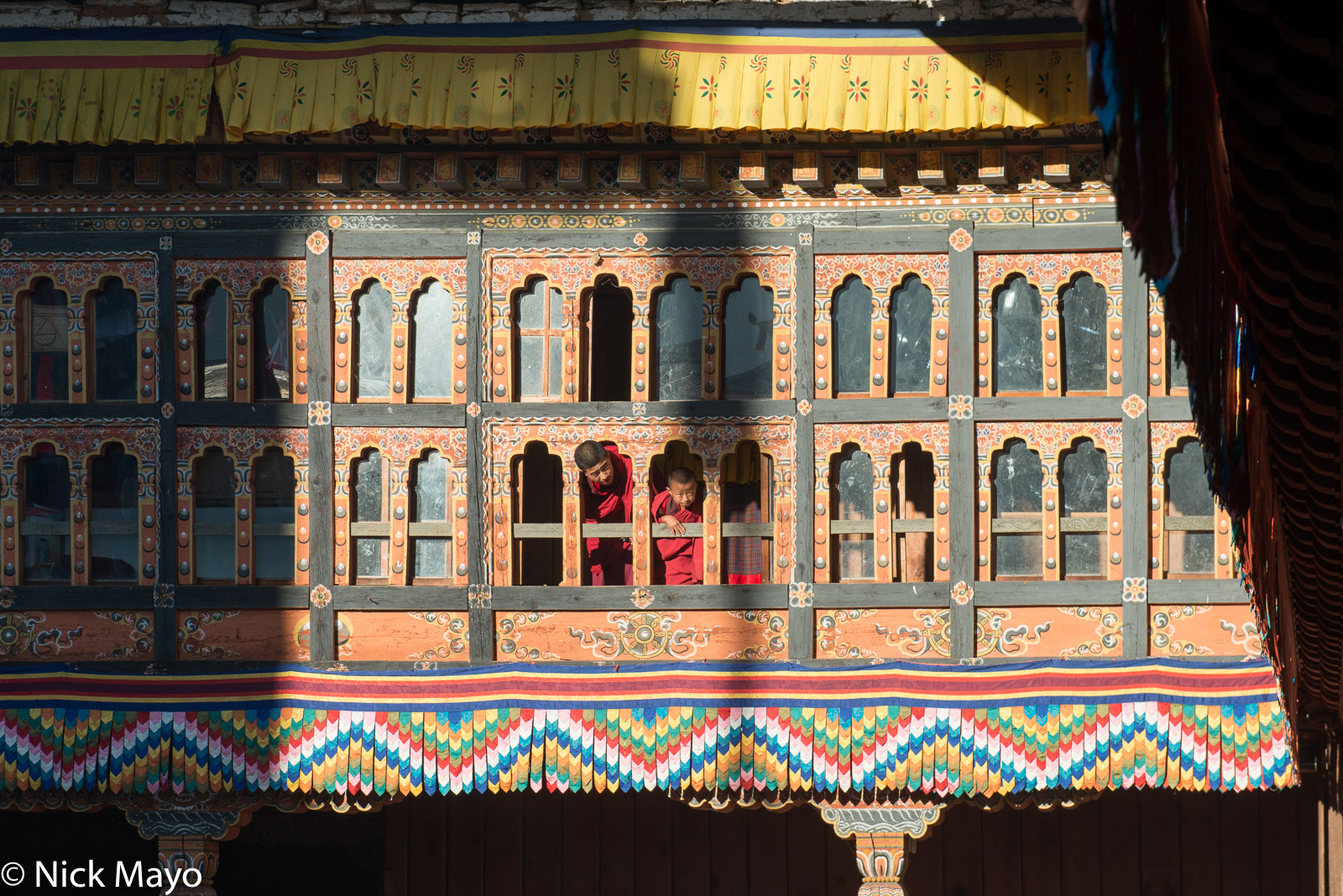 Two monks peering from a dzong window during the annual Mongar tshechu.