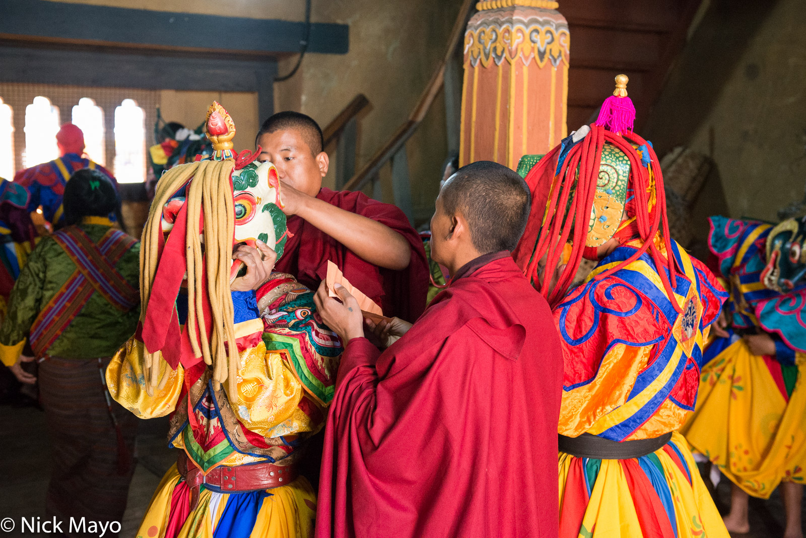 Monks securing a dancer's mask during the annual tshechu at Mongar.