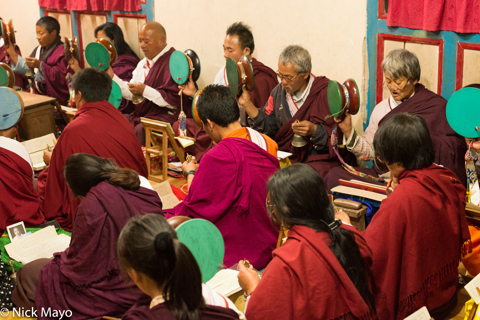 A buddhist chanting group with scriptures, hand drums and bells at Wamrong.