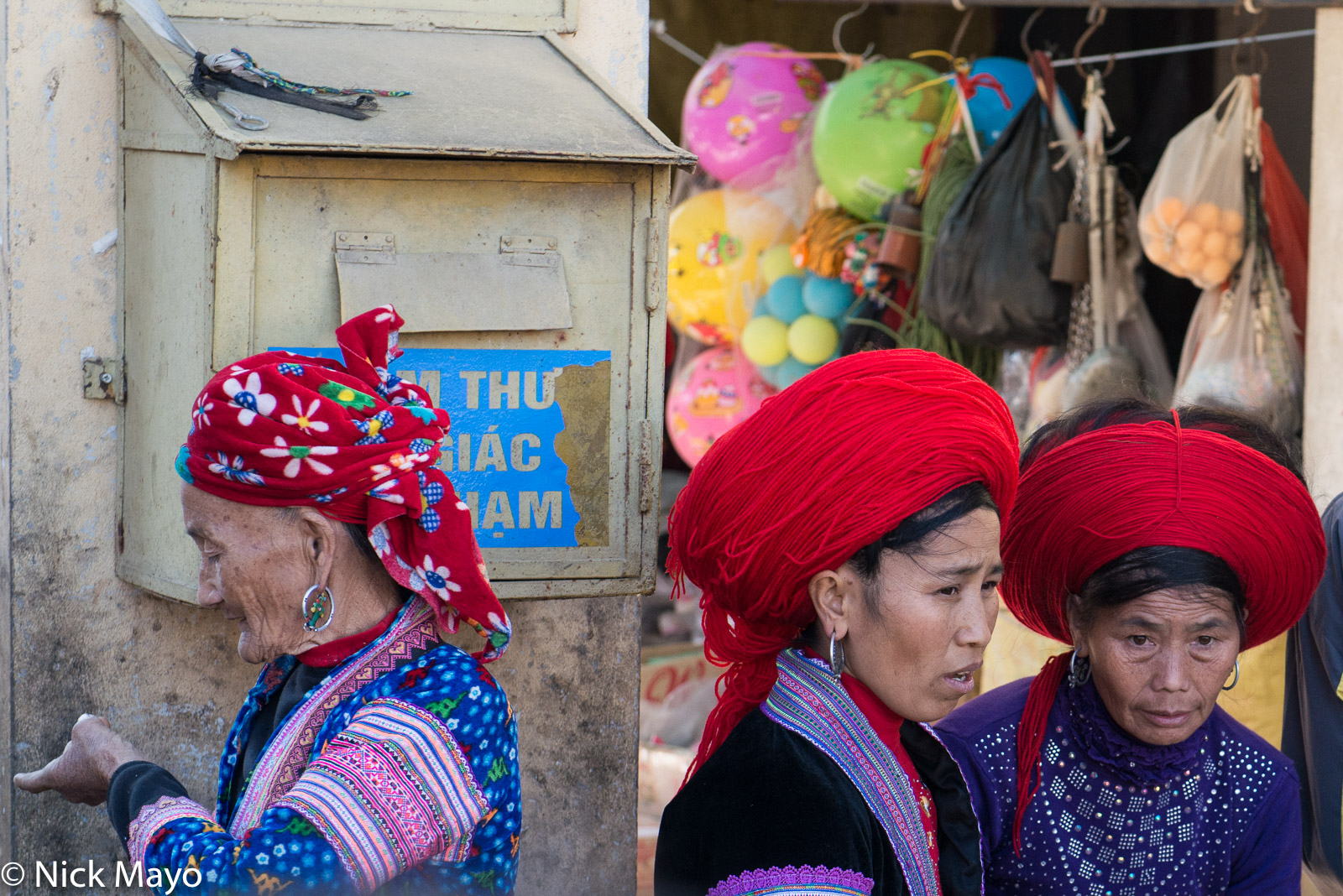 Two Red Hmong (Miao) women wearing hair pieces of wool and a White Hmong woman in a head scarf at Sin Ho.