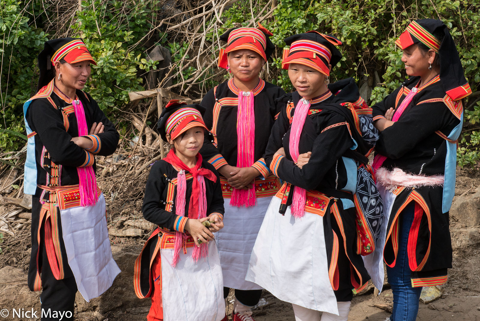 Black Dao (Yao) women in traditional attire of hat, earrings and apron in Ban Then Sin.