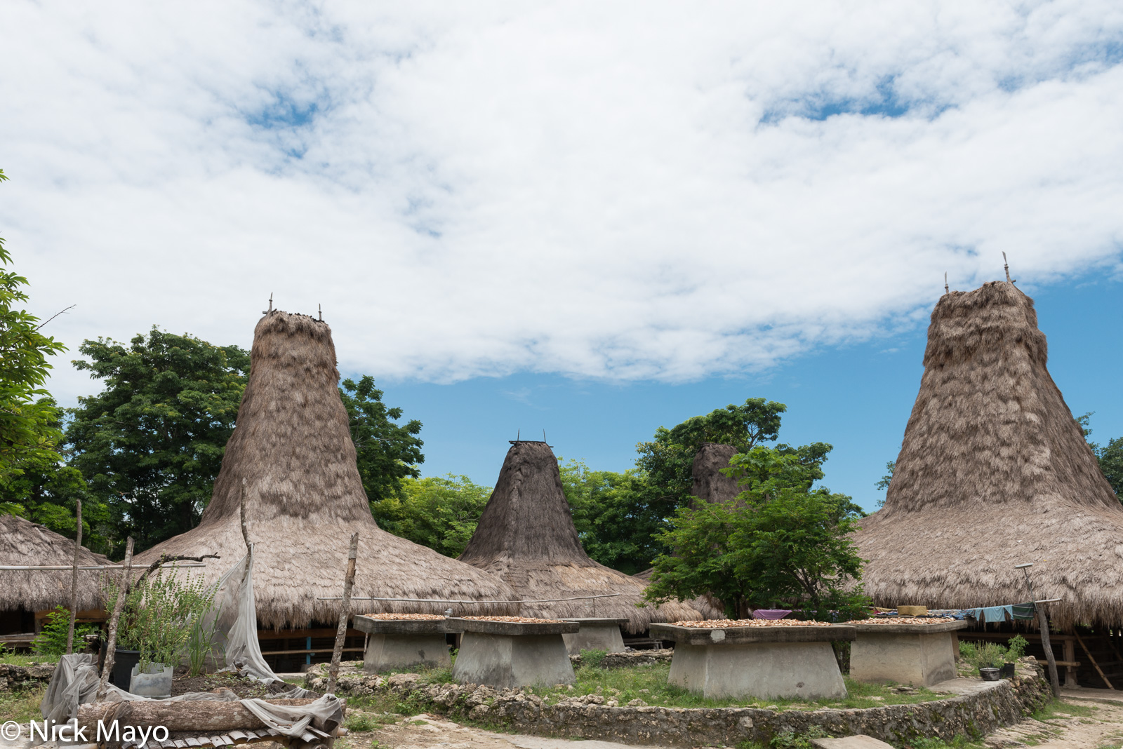 Graves and thatched peak roof houses in a village in West Sumba Regency.