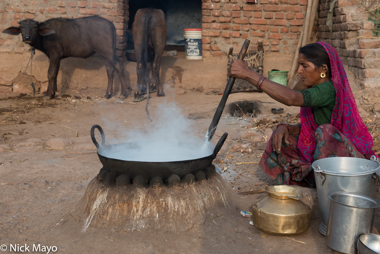 A Bharwad women cooking mawa in a wok on an open hearth in her cow yard at Muli village.