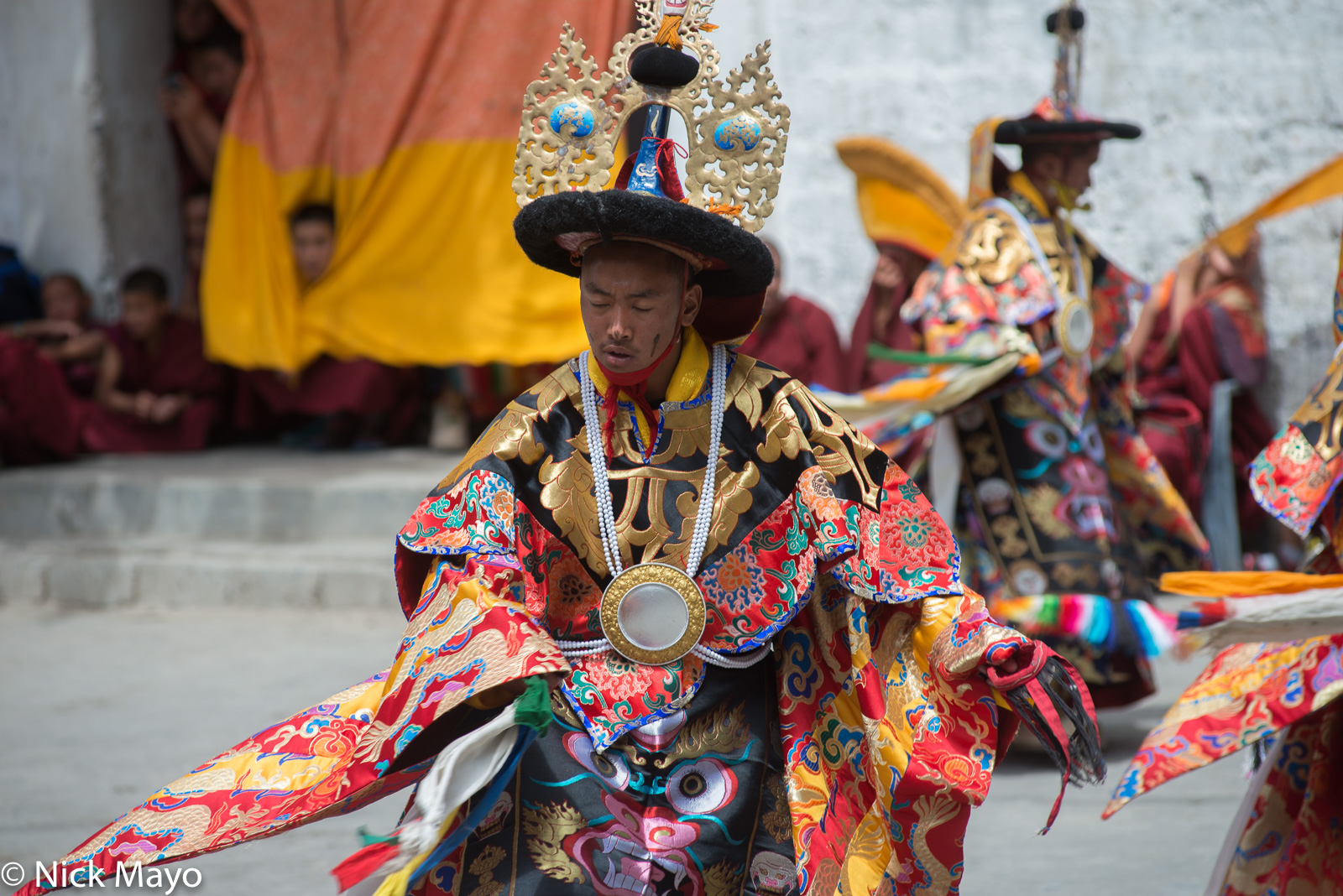 A monk, wearing a ceremonial hat, breastplate and robes, dancing during the festival at the monastery at Ki.