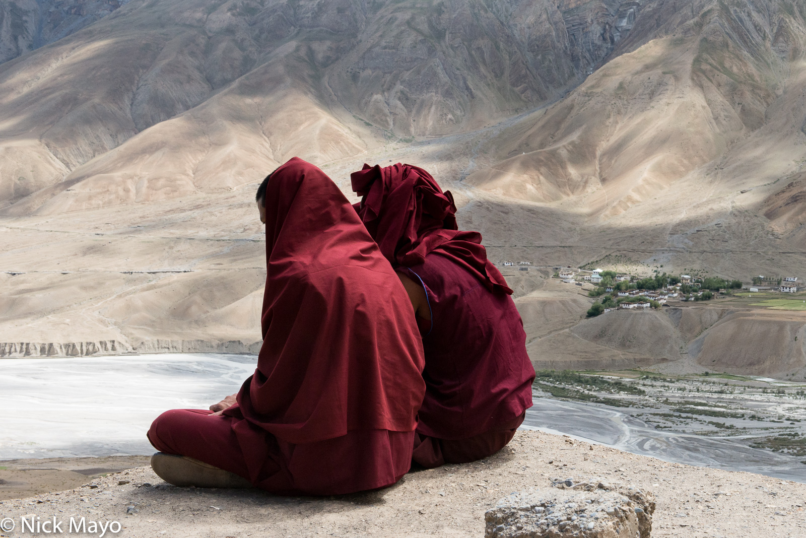 Two monks looking down at the Spiti valley from Ki monastery towards the village of Khurik.